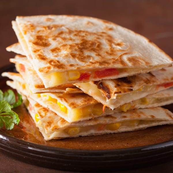 Stack of A1 Fusion Eats Midtown quesadillas filled with melted cheese, corn, and red peppers, garnished with cilantro.